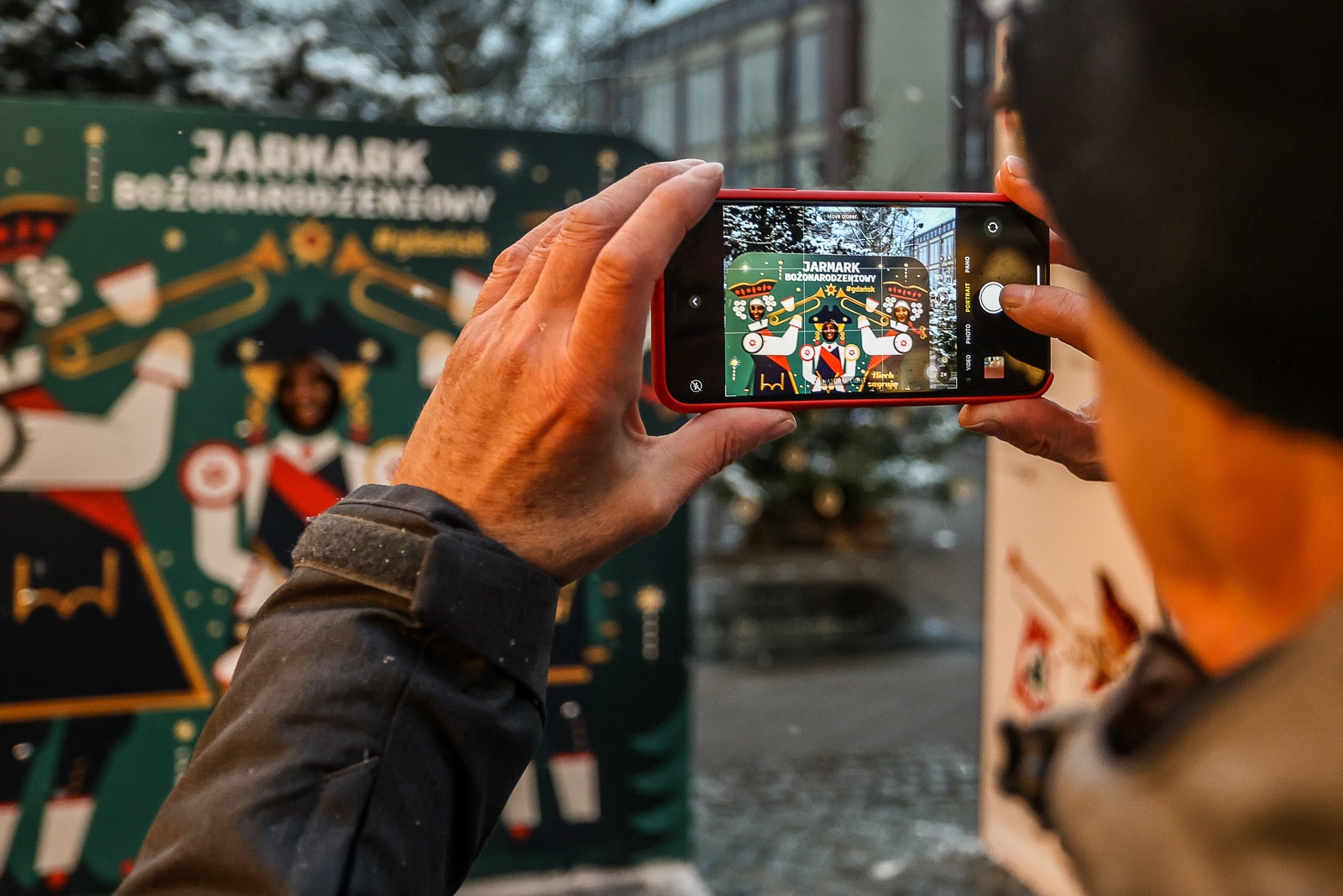 Osoba robi zdjęcie przy ściance fotograficznej na Jarmarku Bożonarodzeniowym