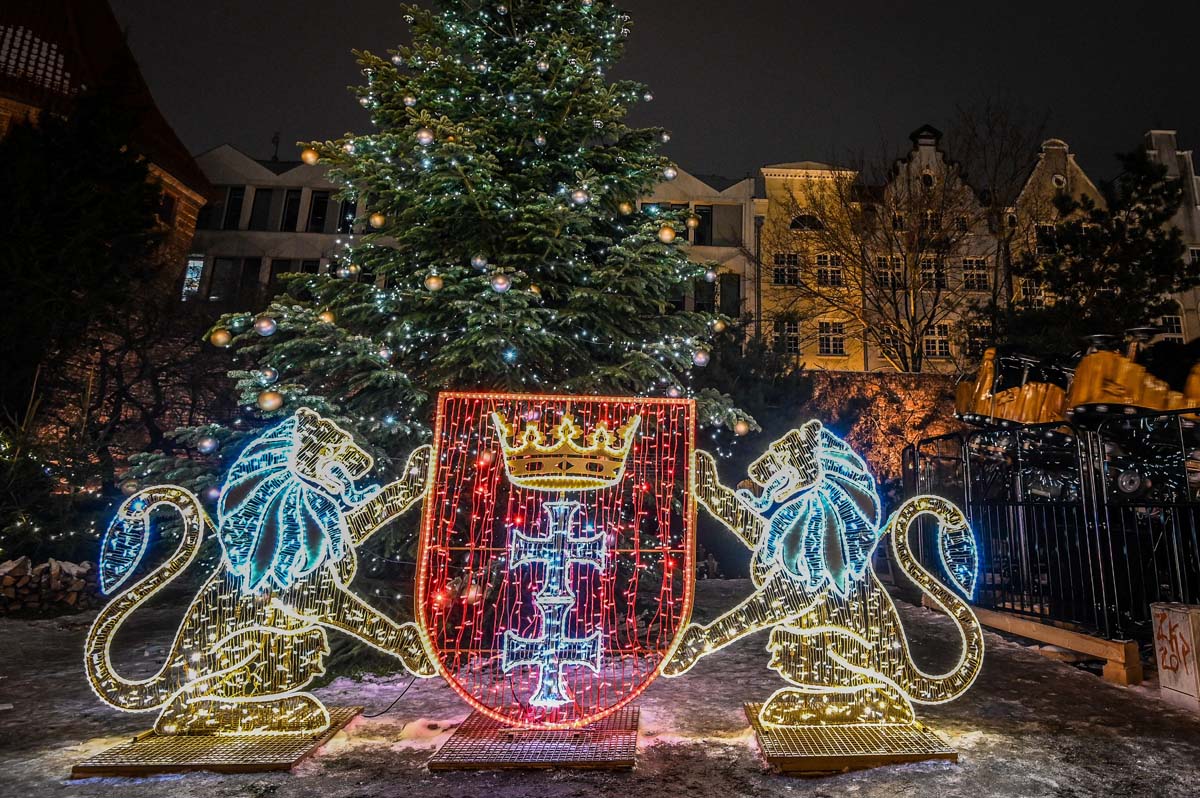 Et par danser i det lysopplyste lysthuset i statsskogene på julemessen i Gdańsk